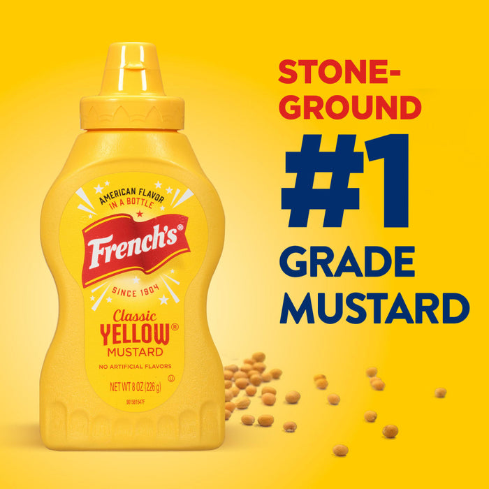 ["A bottle of French's Classic Yellow Mustard with mustard seeds scattered around it."]