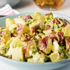 ['A bowl of potato salad with red potatoes, celery, and a creamy dressing.']