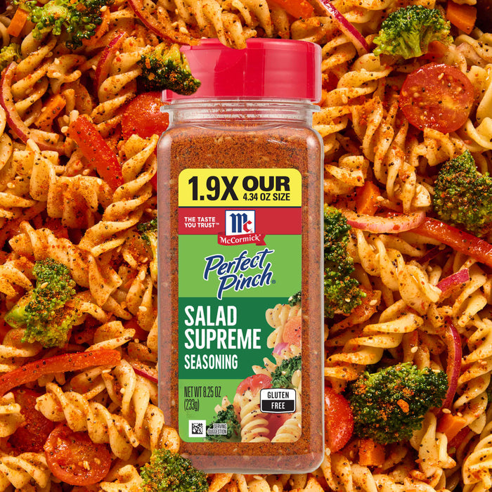 A bottle of McCormick Perfect Pinch Salad Supreme Seasoning is surrounded by a pasta salad.