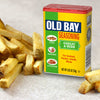 A can of Old Bay Seasoning stands next to a pile of golden french fries, suggesting its use as a flavorful condiment.