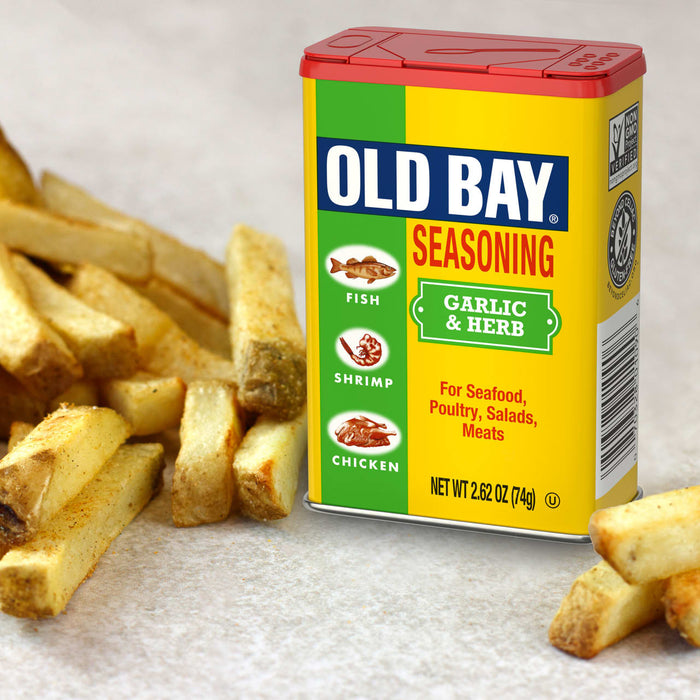 A can of Old Bay Seasoning stands next to a pile of golden french fries, suggesting its use as a flavorful condiment.