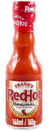 A full glass bottle of Franks Rdhot Orig Gb 24/148 Ml shows the iconic Frank's RedHot Original Cayenne Pepper Sauce label against a black background.