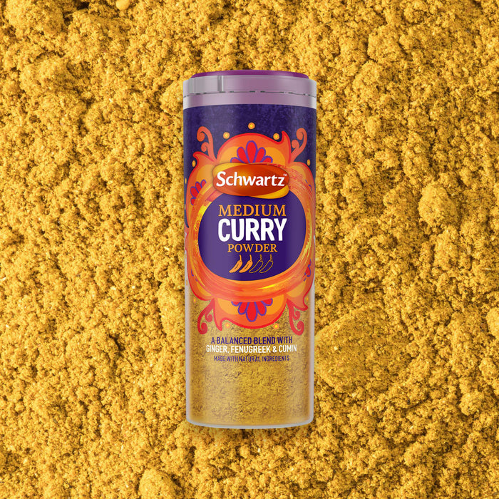 A jar of Schwartz Medium Curry Powder 90G is centered against a background of the loose yellow spice blend.