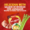 A packet of Schwartz Hollandaise Sauce Mix 25G is displayed on a textured red background alongside fresh asparagus and Parma ham, illustrating the serving suggestion written above.
