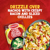 A packet of Schwartz Extra Mature Cheddar Cheese Sauce 30G is displayed next to a serving suggestion of nachos topped with the prepared cheese sauce, crispy bacon, and sliced chillies.