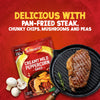 A packet of Schwartz Creamy Mild Peppercorn Sauce Mix 25G is shown next to a perfectly grilled steak in a cast-iron pan, suggesting a delicious meal.