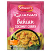 A pink sachet of Schwartz Las Iguanas Bahian Coconut Curry 25G is displayed in front of a black bowl filled with the prepared yellow curry, which contains chicken pieces and is garnished with a lime wedge.