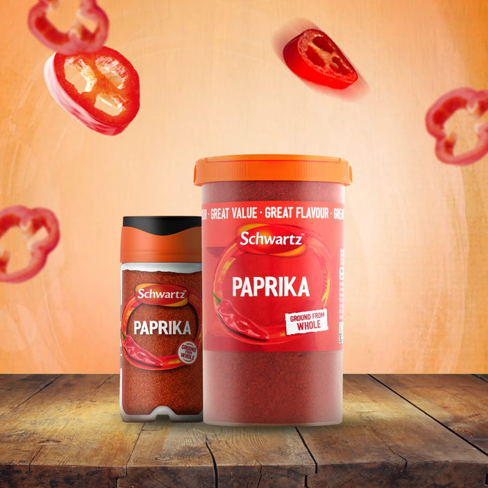 A standard jar and a larger catering tub of Schwartz Paprika 40G are displayed on a wooden table, with slices of red pepper floating in the background.