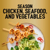 Grilled shrimp skewers seasoned with Jr Garlic Butter Seas X6 are served over a bed of zesty slaw with fresh cilantro and sliced red chilies on a speckled plate.
