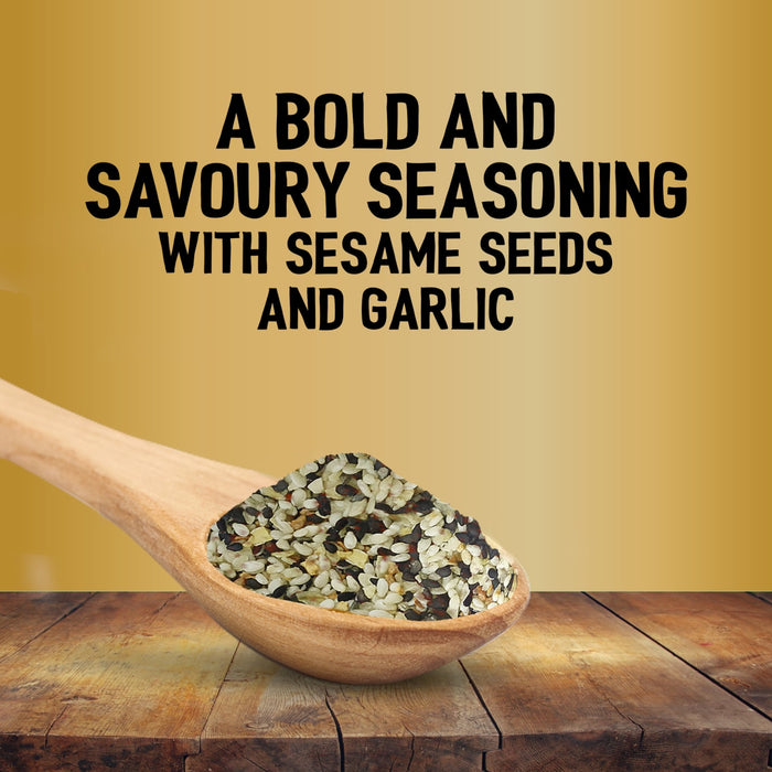 A wooden spoon filled with Jr Every Bagel Seas X6 rests on a rustic table against a gold background with text describing it as a bold and savoury seasoning with sesame seeds and garlic.