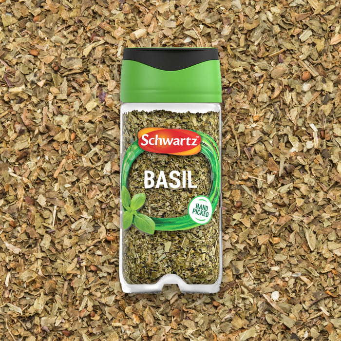A jar of Schwartz Basil 10G is centered against a background of dried green basil leaves.