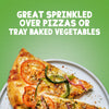A slice of vegetable pizza seasoned with Schwartz Basil 10G is presented on a plate against a green background with text suggesting it is great for pizzas or tray baked vegetables.