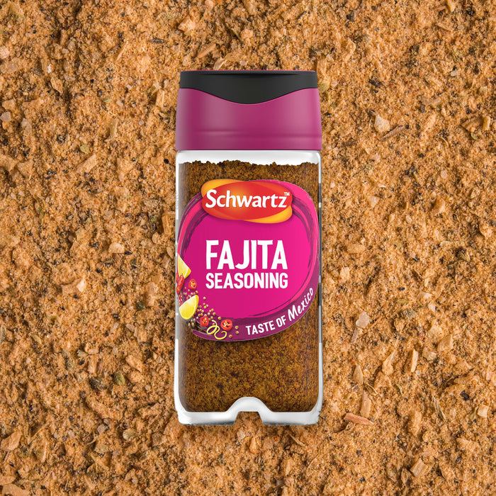 A jar of Schwartz Fajita Seasoning 46G is centered against a background of the loose spice blend.
