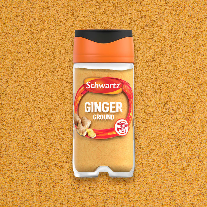 A Schwartz Ground Ginger 26G Jar is centered against a textured background of the same fine golden spice powder.