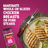 A bottle of Schwartz Classic Bbq Seasoning 44G is displayed next to a plate of grilled chicken breasts and lime wedges to show how it can be used to marinate whole or sliced chicken breasts or pork steaks.