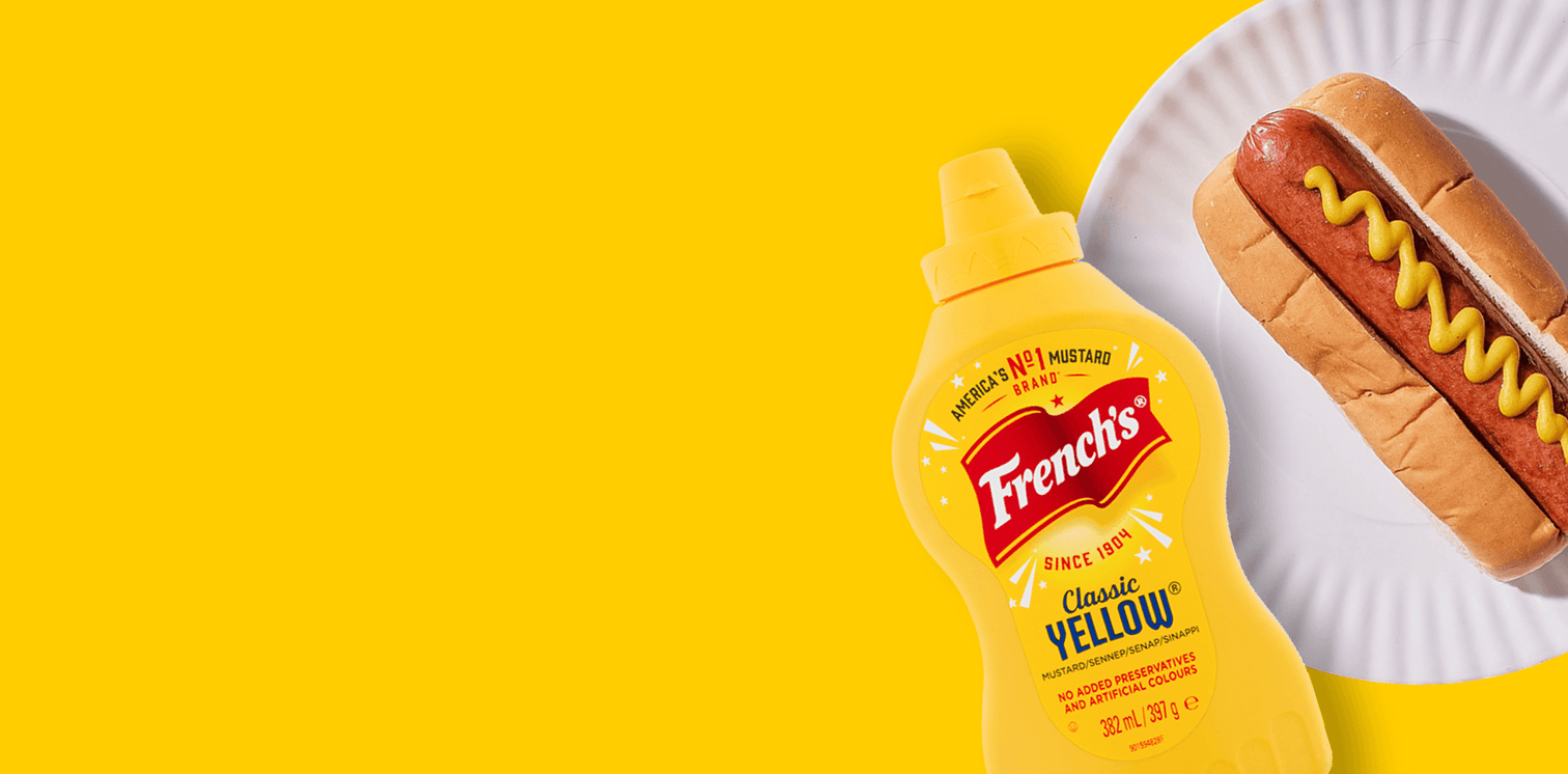 French's yellow mustard bottle with a hot dog on a yellow background