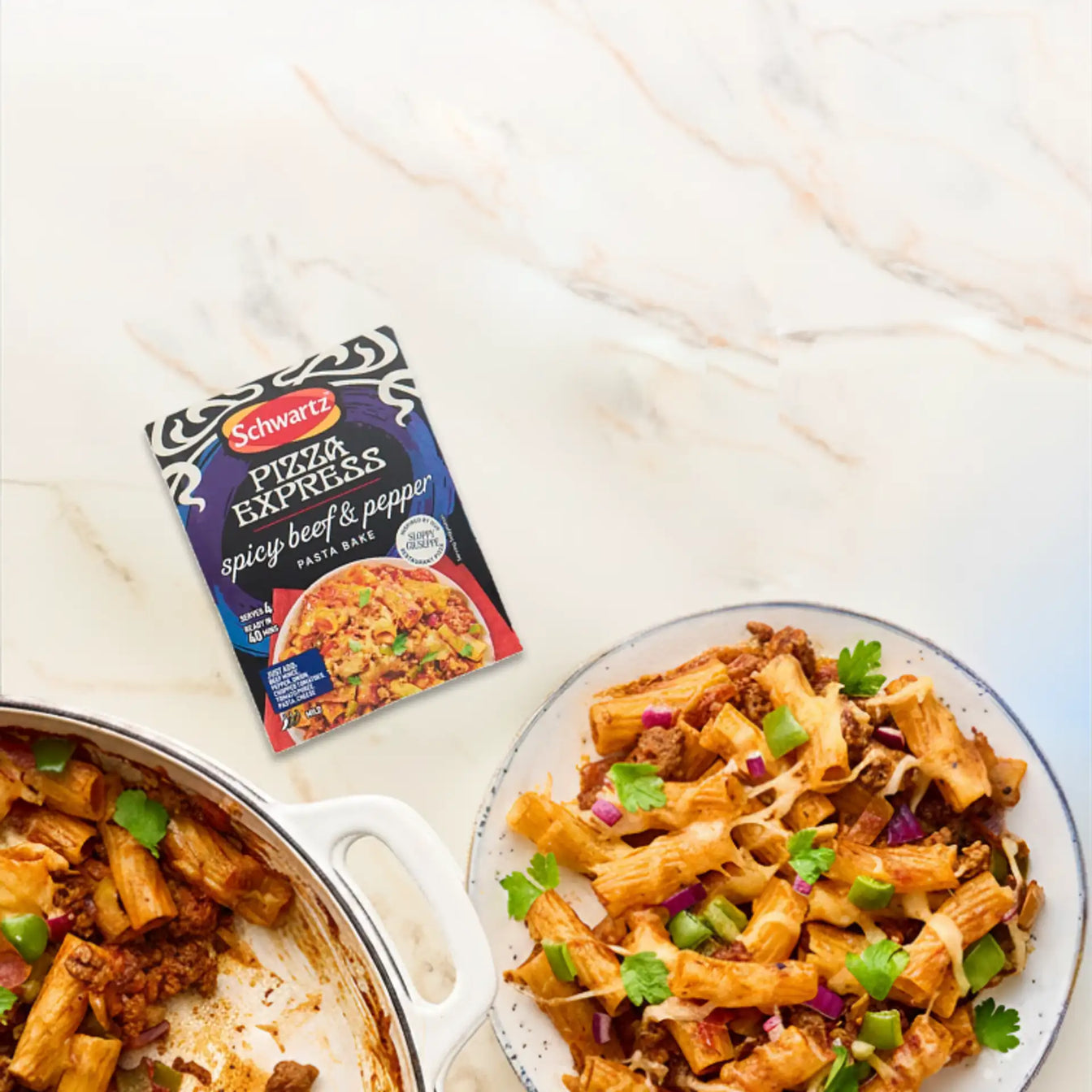 Pasta dish with a package of Schwartz Pizza Express on a table
