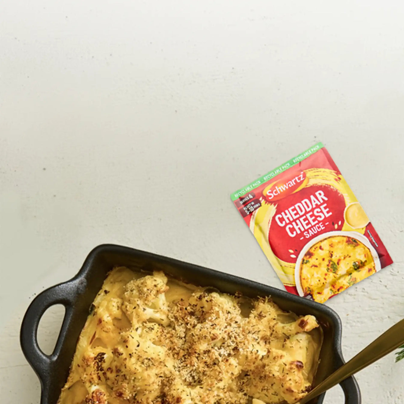 Baked dish with a golden brown topping in a black baking dish on a light gray surface.