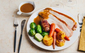gravy next to plate of turkey and veggies