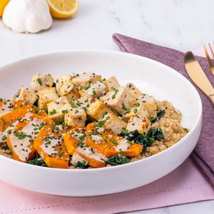 A healthy quinoa bowl with tofu and roasted butternut squash, drizzled with a creamy sauce, presents a delicious meal idea using Barrel seasoning.