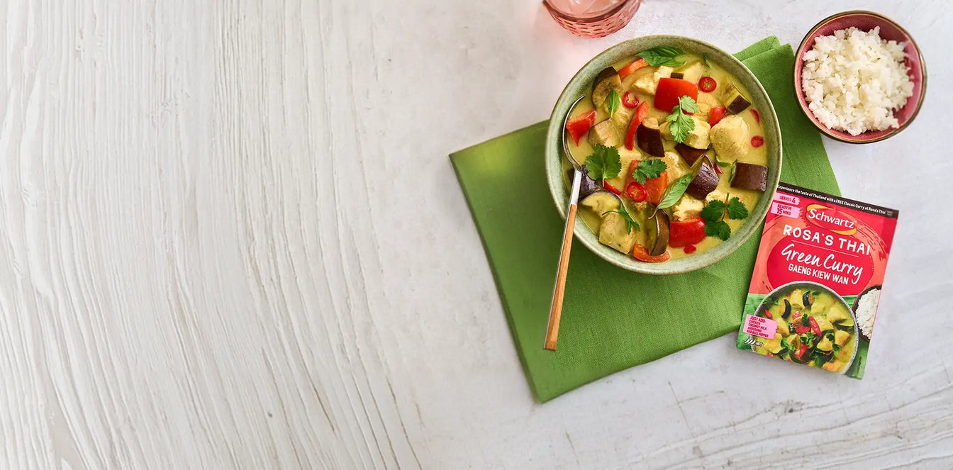 Bowl of vegetable curry with Schwartz Rosa's thai green curry package on a green napkin