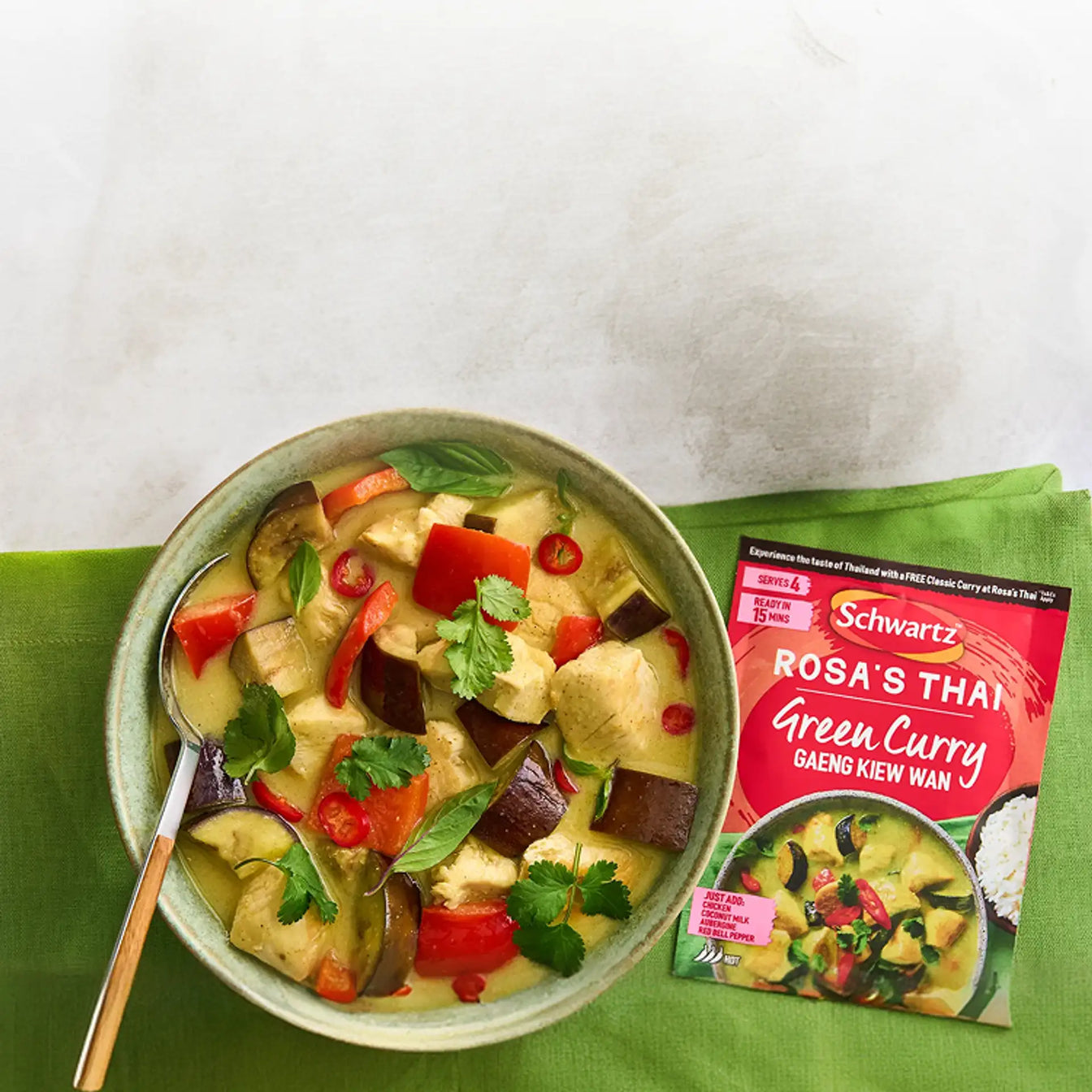 Bowl of vegetable curry with Schwartz Rosa's thai green curry package on a green napkin