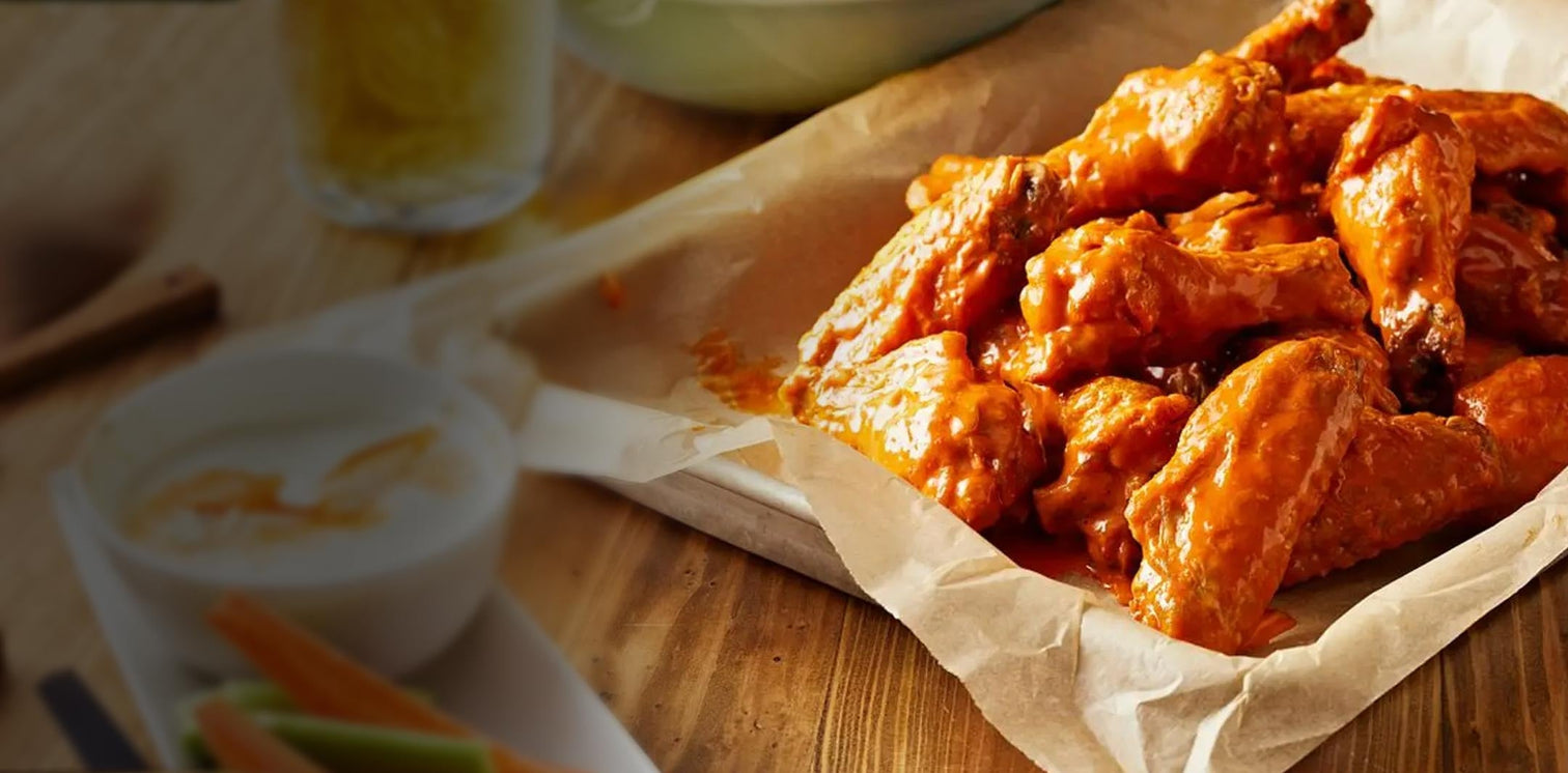 juicy and delicious wings next to blue cheese and celery and carrots