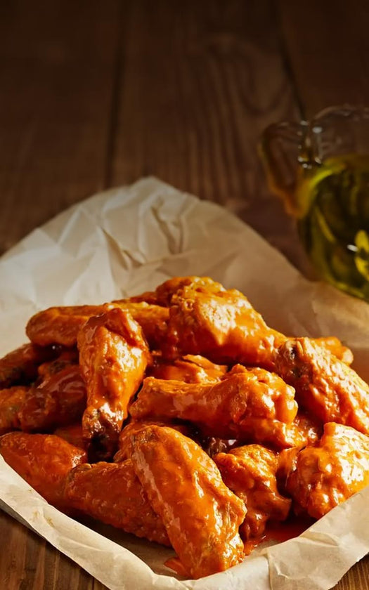 juicy and delicious wings next to blue cheese and celery and carrots