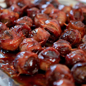A close-up of delicious Barrel bacon-wrapped appetizers glazed in a savory sauce.
