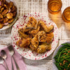 A top-down view shows a rustic meal of roasted chicken, potatoes, and green beans, with drinks served in two amber-colored Barrel glasses.