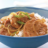 A close-up of a savory meat and onion dish served over rice in a blue bowl, a delicious meal idea that can be created using the Barrel product.